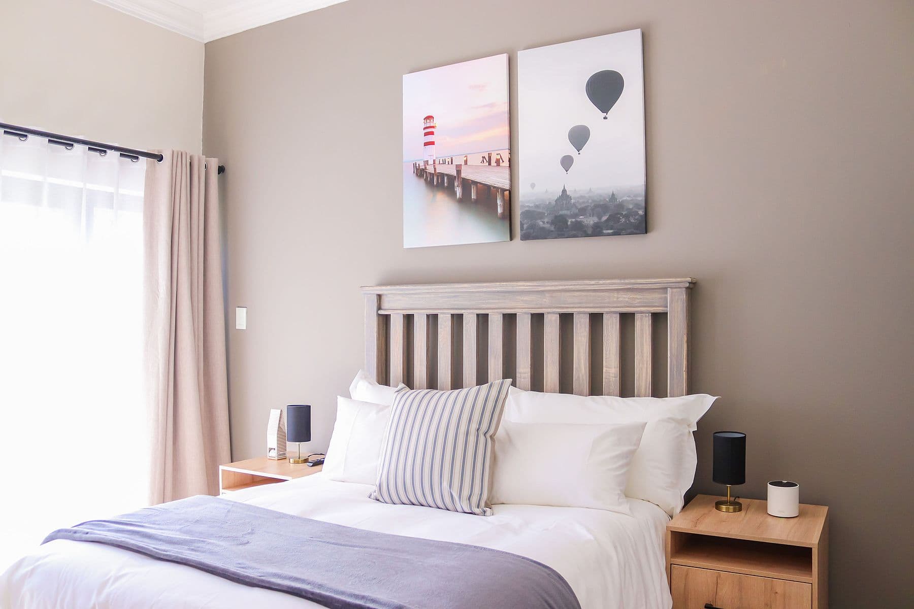 Charcoal Room: bed with grey throw and framed prints
