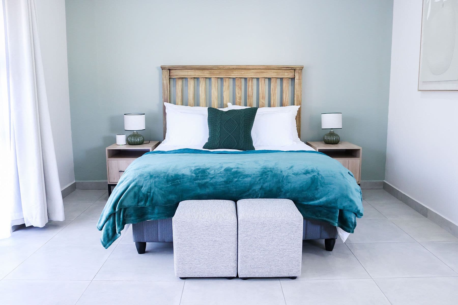 Teal Suite: bed with teal throw and ottomans