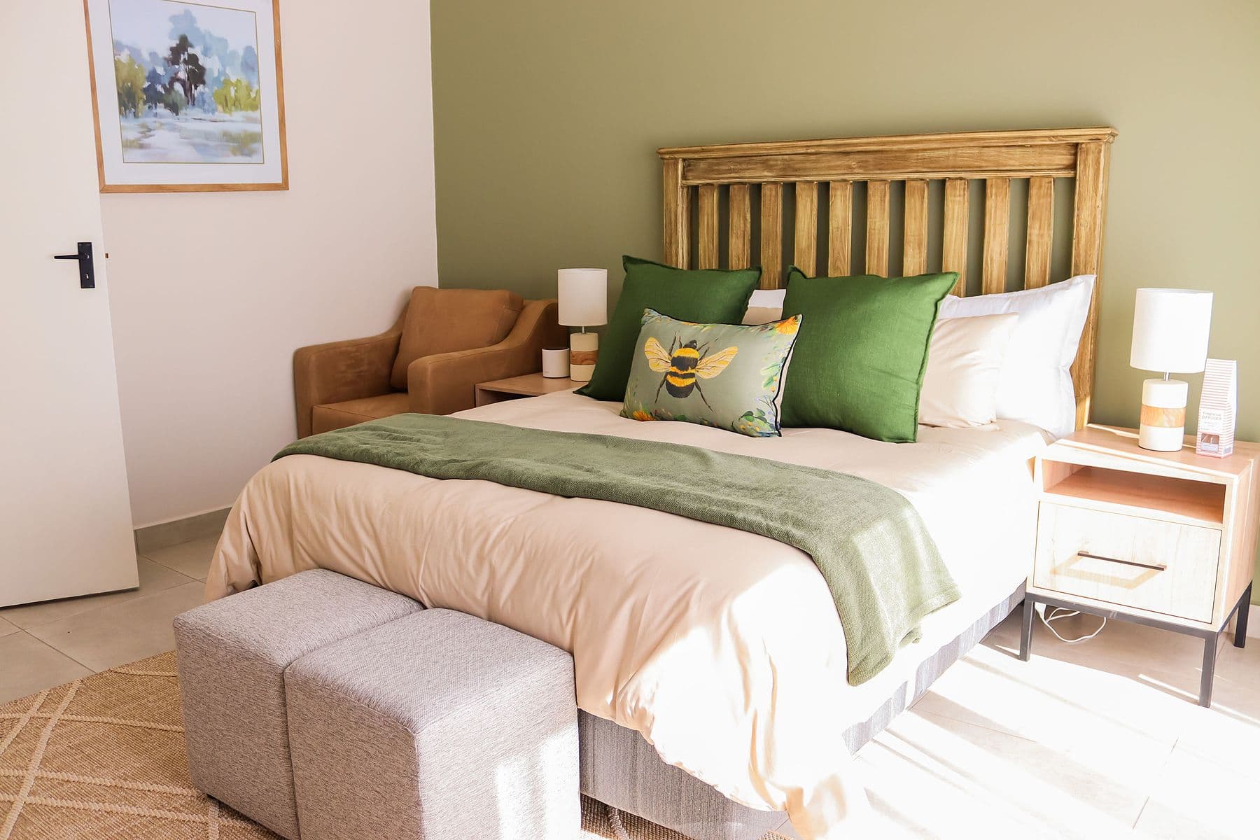 Sage Room: bed with green cushions and timber headboard