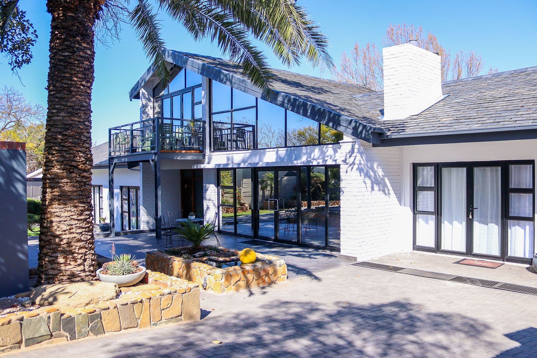 The glass gable and courtyard under the palms